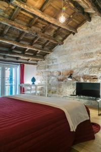 巴勒莫Corte del Merlo的一间卧室设有一张大床和石墙