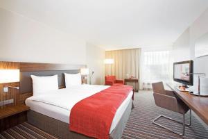 格拉特布鲁格苏黎世机场瑞享酒店的酒店客房设有一张大床和一张书桌。