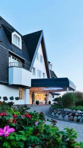 韦斯特兰多林特海滩度假村及威斯特兰/叙尔特Spa中心的带阳台和鲜花的大型白色房屋