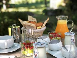 圣艾米隆拉格梅里尚布斯德霍特斯旅馆的一张桌子,上面有食物和一篮水果及果汁