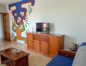 圣克鲁斯-德拉帕尔马Apartamento ARENA en Santa Cruz de la Palma的客厅的橱柜顶部配有电视