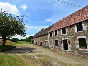 Montaigu-les-BoisCharming holiday home in a green setting的一座古老的石头谷仓,旁边是一条土路