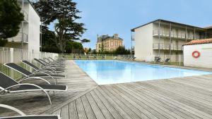 拉戈尔瓦坎斯奥勒 - 城堡庄园 - 拉罗谢尔/雷岛公寓式酒店的木制甲板上带椅子的游泳池
