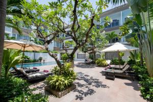 岘港Grandvrio City Danang By Route Inn Group的庭院设有游泳池、椅子和一棵树