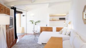 切尔沃港LUX-Porto Cervo Center Sea View Apartment的白色卧室配有床和桌子