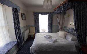 彭赞斯联盟酒店的一间卧室设有一张大床和窗户