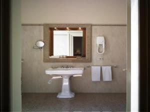 雷扎托福娜罗丽别墅皇宫酒店的浴室配有盥洗盆、镜子和毛巾