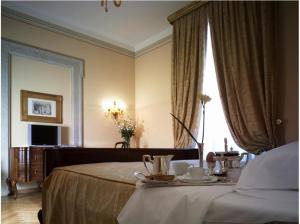 雷扎托福娜罗丽别墅皇宫酒店的酒店客房,配有一张带茶具的桌子。