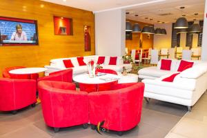 圣丹尼斯郁金香圣克洛蒂尔德酒店的餐厅设有红色和白色的椅子和桌子
