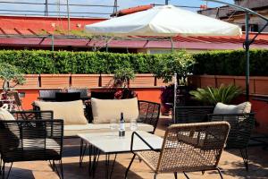 罗马罗马重启公寓的庭院配有桌椅和遮阳伞。