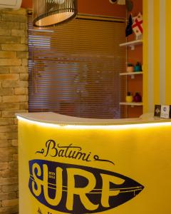 巴统巴统冲浪旅馆的上面有冲浪标志的黄色柜台