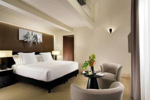 罗马The First Dolce - Preferred Hotels & Resorts的配有一张床和一把椅子的酒店客房