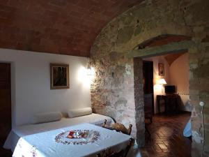 托里塔迪谢纳Podere Alberello的一间卧室设有一张床和石墙