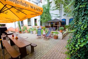 德累斯顿梅兹卡洛宾馆的一个带桌椅和遮阳伞的庭院