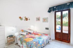 卡波利韦里Hotel Giardino的一间卧室配有一张带彩色毯子的床