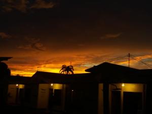 别霍港卡露耐旅舍的落日,在房子的屋顶上,棕榈树