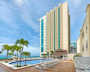 圣多明各圣多明各加泰罗尼亚酒店的一座拥有游泳池和棕榈树的酒店