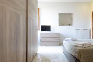 MassignanoB&B Alba sul Mare的一间卧室配有一张床,梳妆台上配有电视