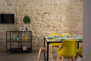 波扎洛Funduq ospitalità iblea的一间带桌子和黄色椅子的用餐室
