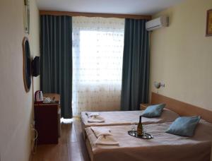 巴尔奇克Ahilea Hotel - Free Pool Access的一间卧室配有一张带桌子和窗户的床