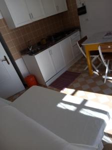 MontaleAppartamento in dimora tipica的厨房配有白色橱柜、桌子和桌椅