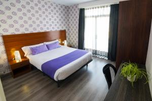 卡里拉阿萨瓦拉公寓式酒店的一间卧室配有一张带紫色枕头的大床