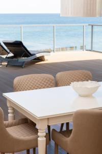 济夫努夫Apartamenty The View Gardenia的白色的桌椅,享有海景