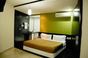 韦拉克鲁斯波托诺瓦酒店的一间卧室配有一张带绿色墙壁的床