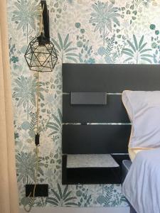 瓦尔米耶拉ROOM 10的一间卧室配有一张床和一张带花卉壁纸的墙壁