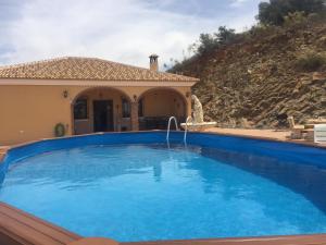 AlmogíaCasa Cuatro Vientos - Barranco Del Sol的一座大蓝色游泳池,位于房子前