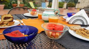 帕埃斯图姆Casa del Geco的餐桌,盘子上放着食物和水果碗