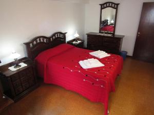 Lajes das FloresCasa L&M的一间卧室配有红色的床和镜子