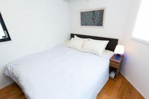 东京Sangen-jaya House-O的卧室配有白色的床和床头柜