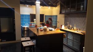 京丹后市Asobi Lodge的站在厨房的女人