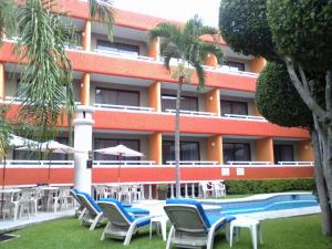 库埃纳瓦卡Hotel Real del Sol的一个带椅子的度假胜地、一个游泳池和一座建筑