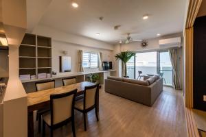 北谷町MINATO Chatan Seaside Condominium的厨房以及带桌子和沙发的客厅。