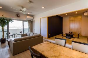 北谷町MINATO Chatan Seaside Condominium的客厅配有沙发和桌子