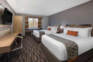 佛罗伦萨Microtel Inn & Suites by Wyndham Florence的酒店客房设有两张床和一台平面电视。