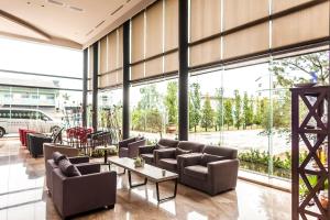 嘉义市乐亿皇家渡假酒店  的大堂配有沙发、桌子和大窗户。