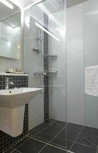 首尔江南欧克劳德酒店的一间带水槽和玻璃淋浴的浴室