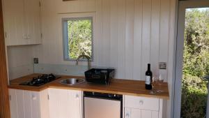 布德The Wheelhouse的厨房配有水槽和带一瓶葡萄酒的吧台。