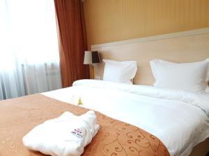 阿斯塔纳阿斯塔纳国王酒店的配有2张床铺的酒店客房,提供白色床单和枕头