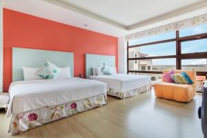 马公海之径民宿的橙色墙壁客房的两张床
