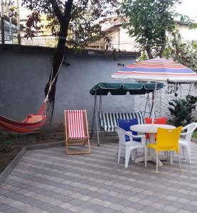 库塔伊西Apartment 19的庭院配有桌椅和遮阳伞。