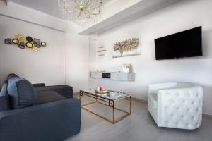 尼基季Royalty Suites Loft的带沙发、桌子和电视的客厅