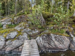 KylmäläHoliday Home Artturin mökki by Interhome的森林中一条河上的木桥