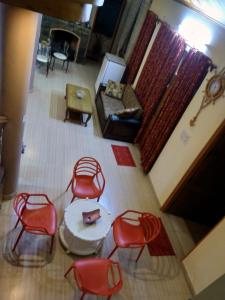 索兰AMBIKA HOME STAY的享有带红色椅子和桌子的客厅的顶部景色。