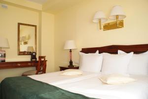 皮佐维斯维尔加卡托维兹机场酒店的卧室配有一张带镜子的白色大床