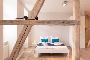 塞巴特阿尔贝克OSTKÜSTE - Villa Albatros Design Apartments的一间卧室配有带蓝色枕头的阁楼床