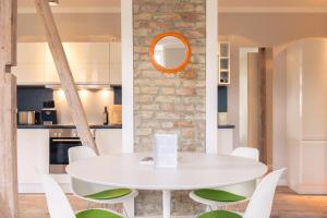 塞巴特阿尔贝克OSTKÜSTE - Villa Albatros Design Apartments的白色的用餐室配有白色的桌椅